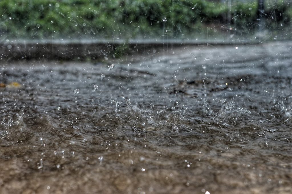 Niederschlag fällt auf den Boden und sickert teilweise ins Grundwasser.