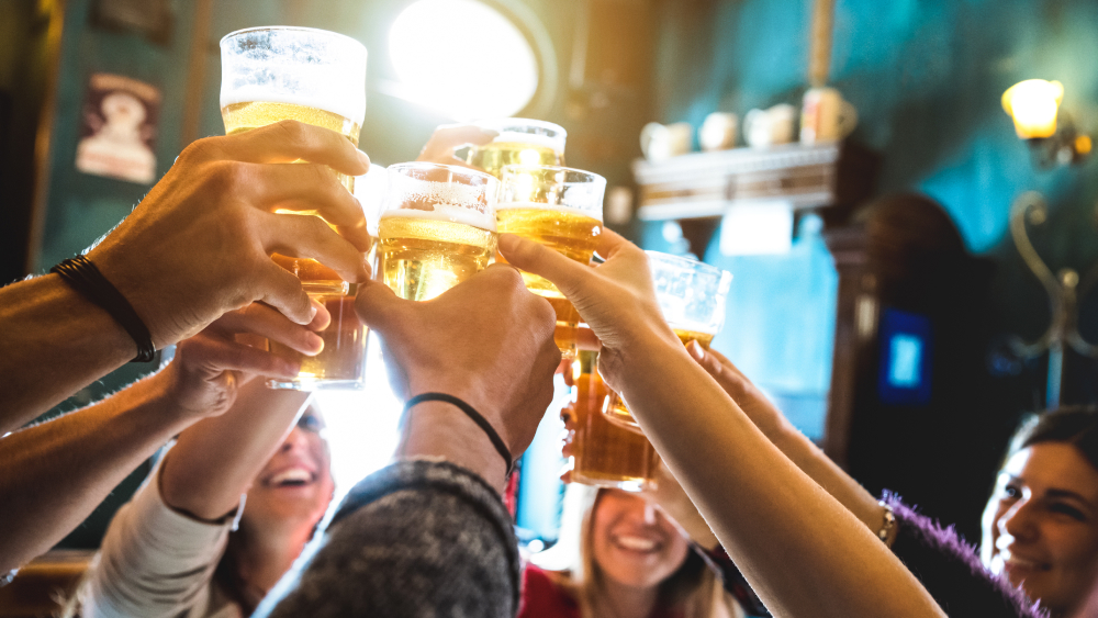 Eine Gruppe von Personen prostet sich mit Biergläsern zu.