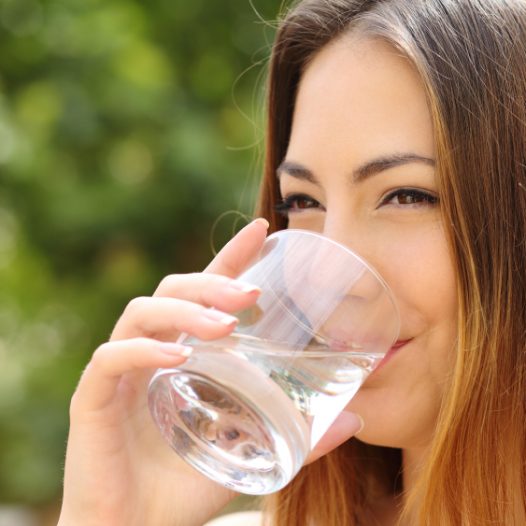 Frau trinkt aus Wasserglas