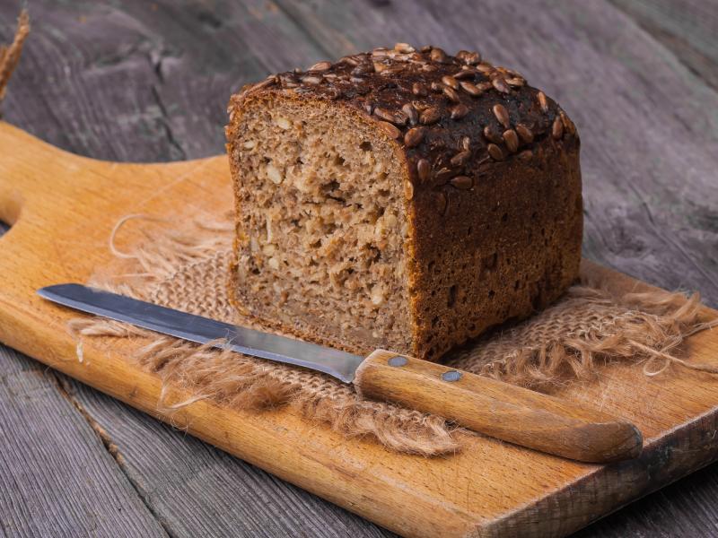 Geschnittenes Vollkornbrot auf einem Holzbrett.