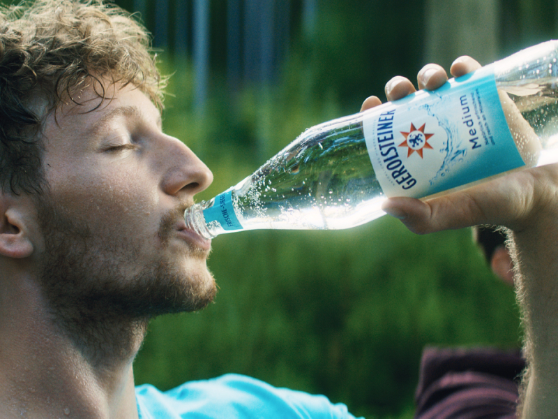 Man trinkt Gerolsteiner Medium aus einer Glasflasche.