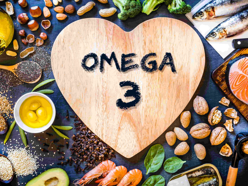 Lebensmittel, die Omega-3-Fettsäuren enthalten. Darunter Samen, Avocado, Fisch, Spinat, Brokkoli und Nüsse.