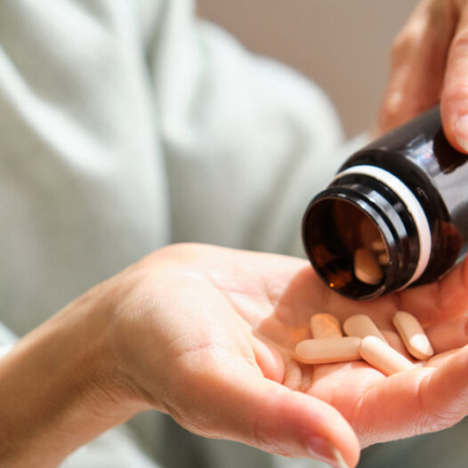 Frau hält Supplements in der Hand