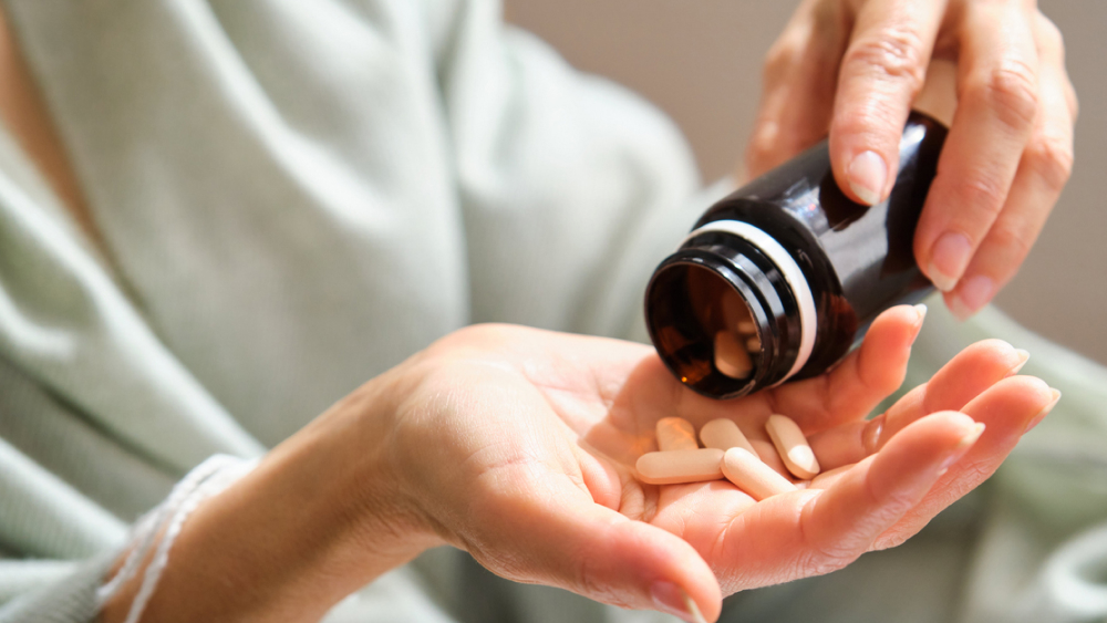 Frau hält Supplements in der Hand