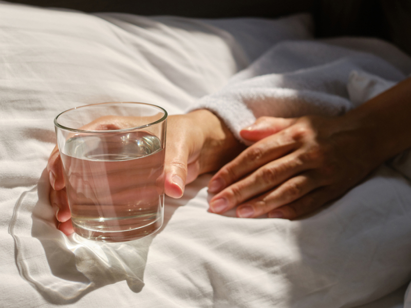 Ein Glas Wasser auf dem Bett
